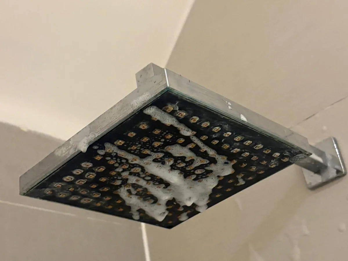 A shower head clogged with limescale before cleaning