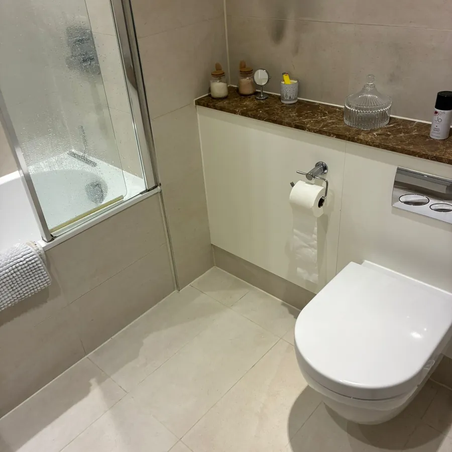 A bathroom taken back to clean, with descaled tiles, taps and glass